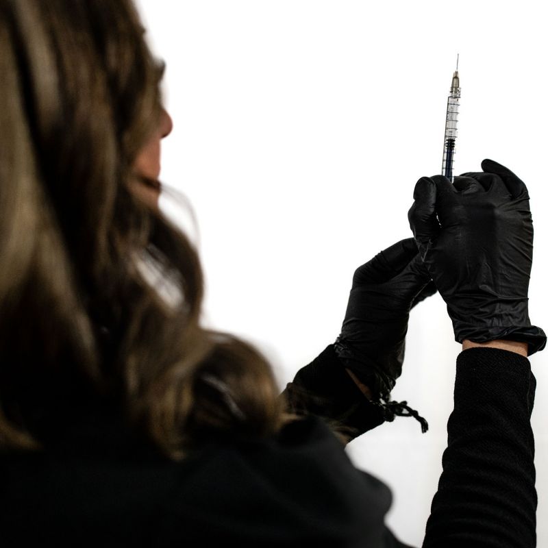 Photo of a woman getting ready to perform aesthetic treatments and injectables on a client.